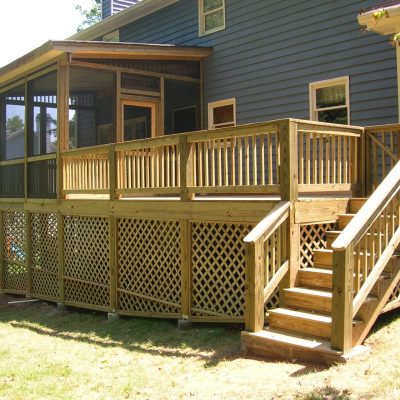Discover the charm of a wooden deck with lattice skirting and stairs, beautifully enhanced by Painting Plus. This outdoor oasis, attached to a two-story house, features a screened-in porch area perfect for relaxation and entertainment.