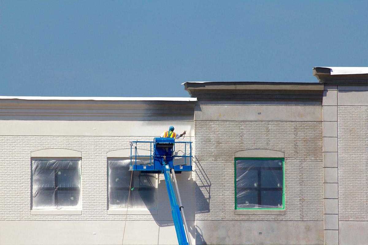 Construction team installs new roof gutters under sunny blue sky