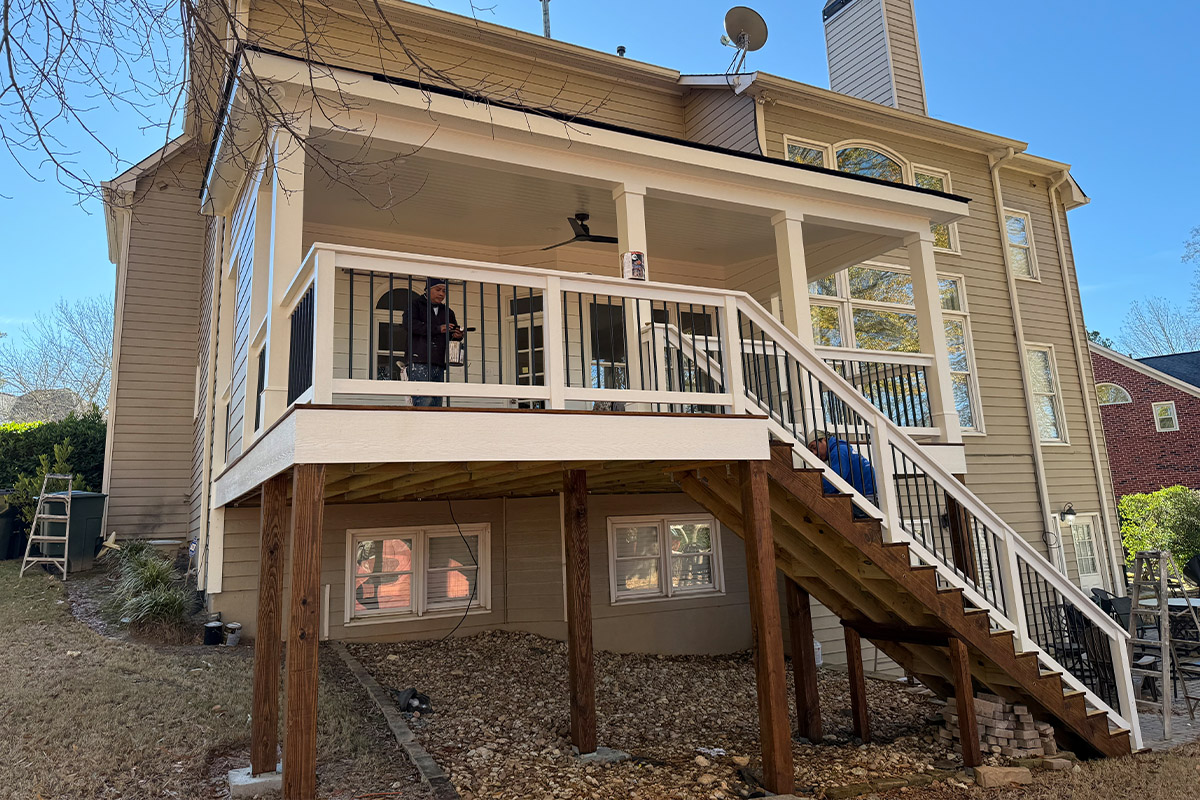 Construction team installs new roof gutters under sunny blue sky